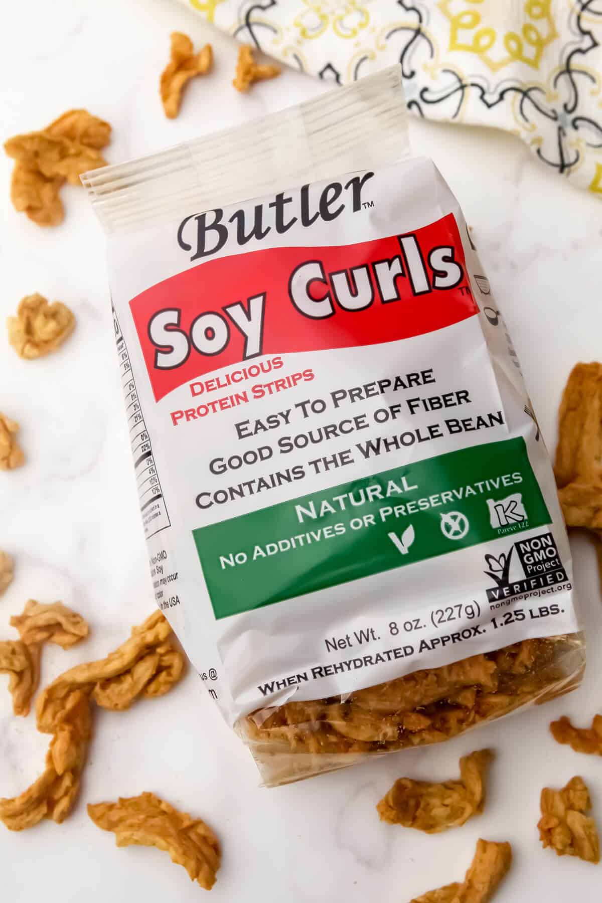 A bag of Butler Soy Curls with soy curls around it.