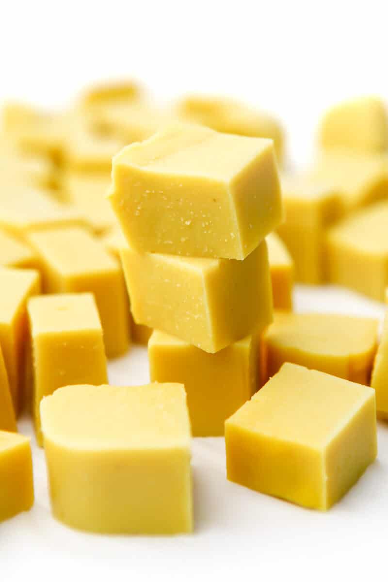 Cut squares of chickpea tofu on a white surface.