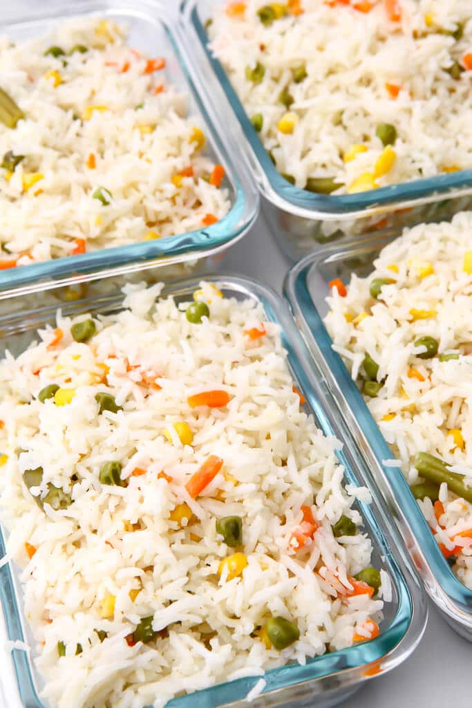 Four containers filled with Thai coconut rice to be store in the fridge or freezer for meal prep.