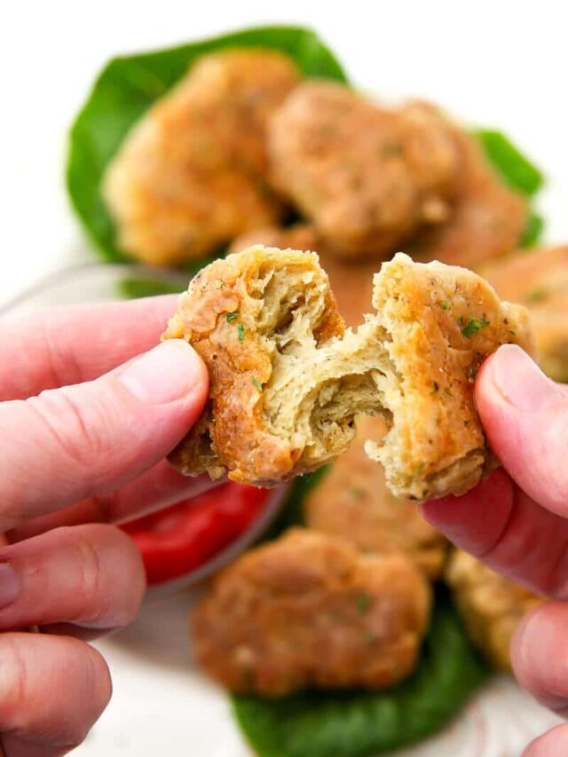 A close up of a vegan chicken nugget being ripped apart.