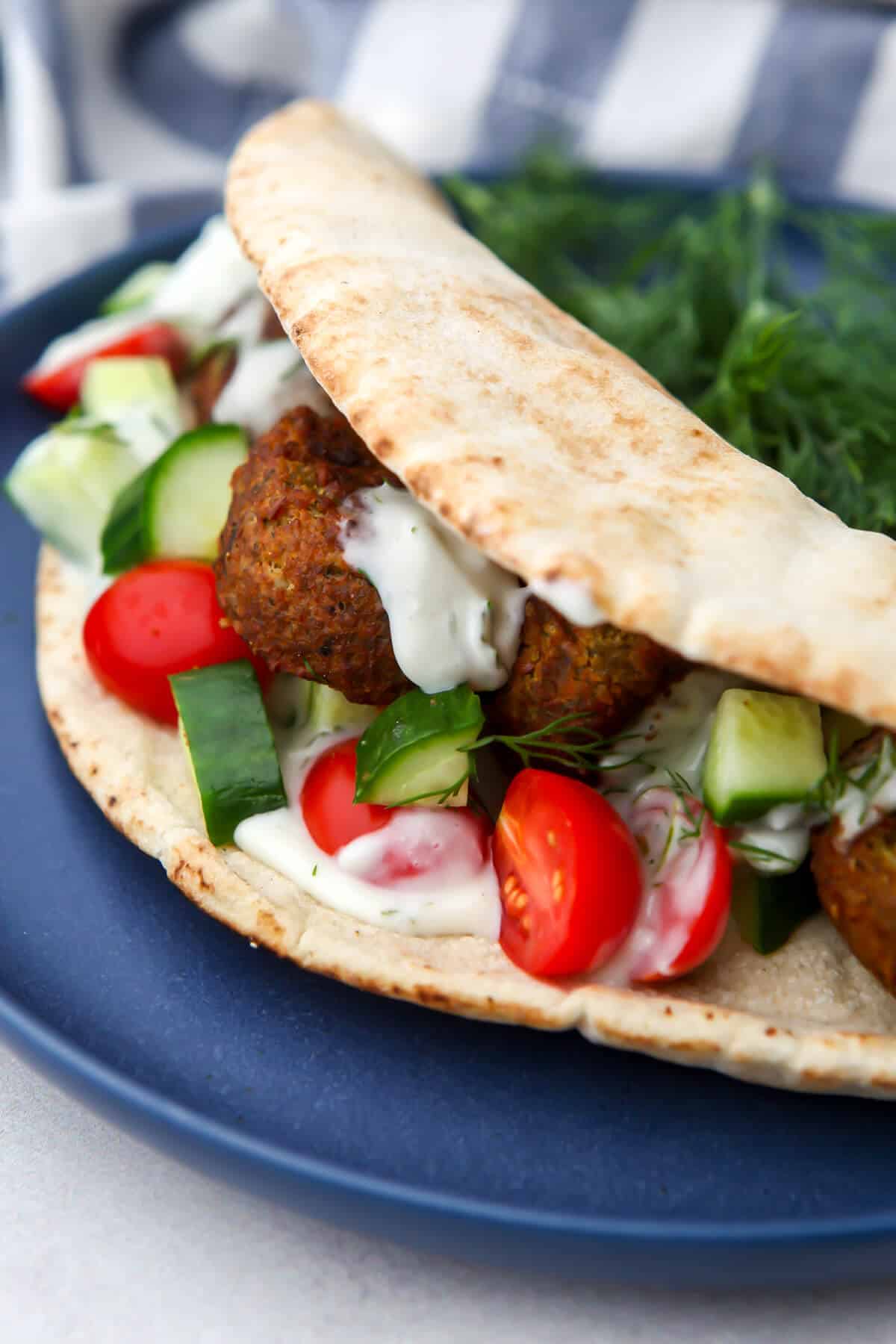 A falafel gyro wrap on a blue plate.