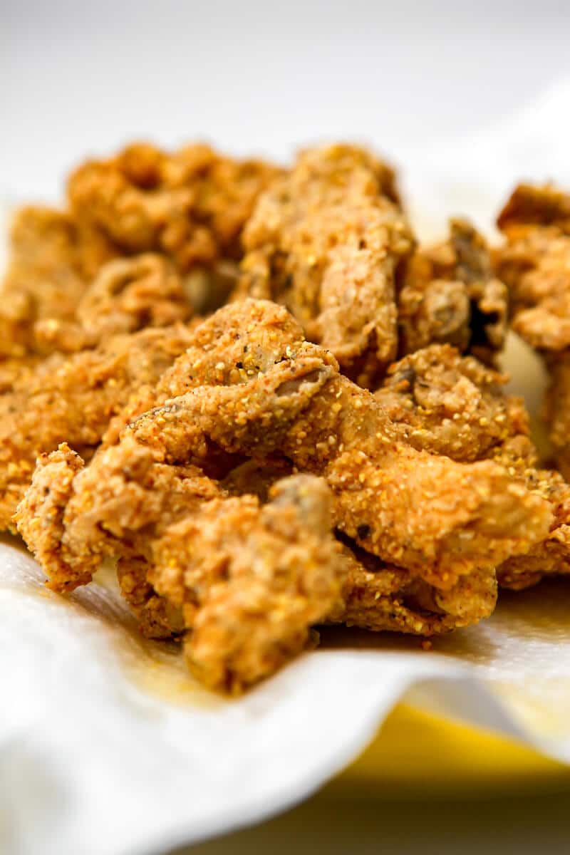 Vegan fried oyster mushroom cooling on a paper towel after they have been fried.