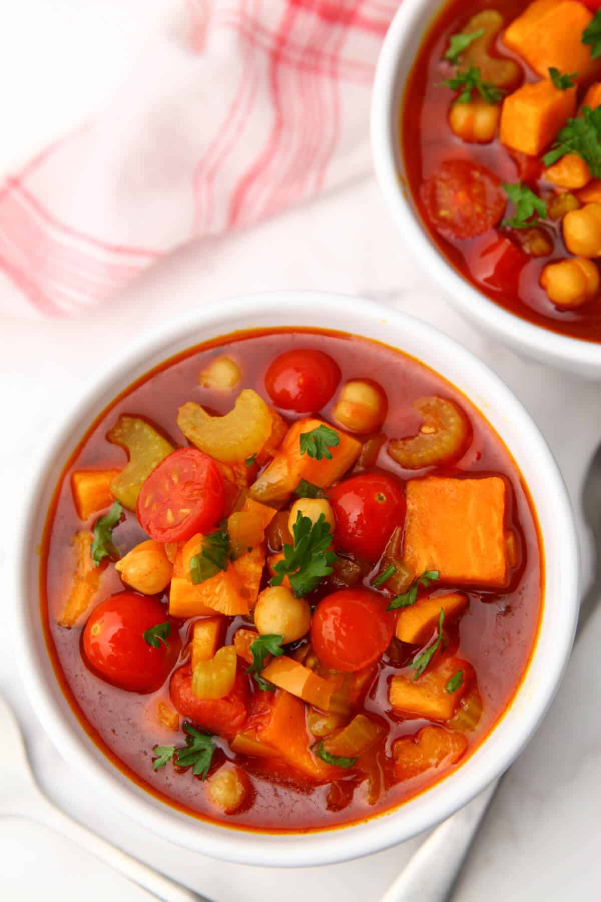 Two bowls of gypsy soup with a red and white tea towel next to them.