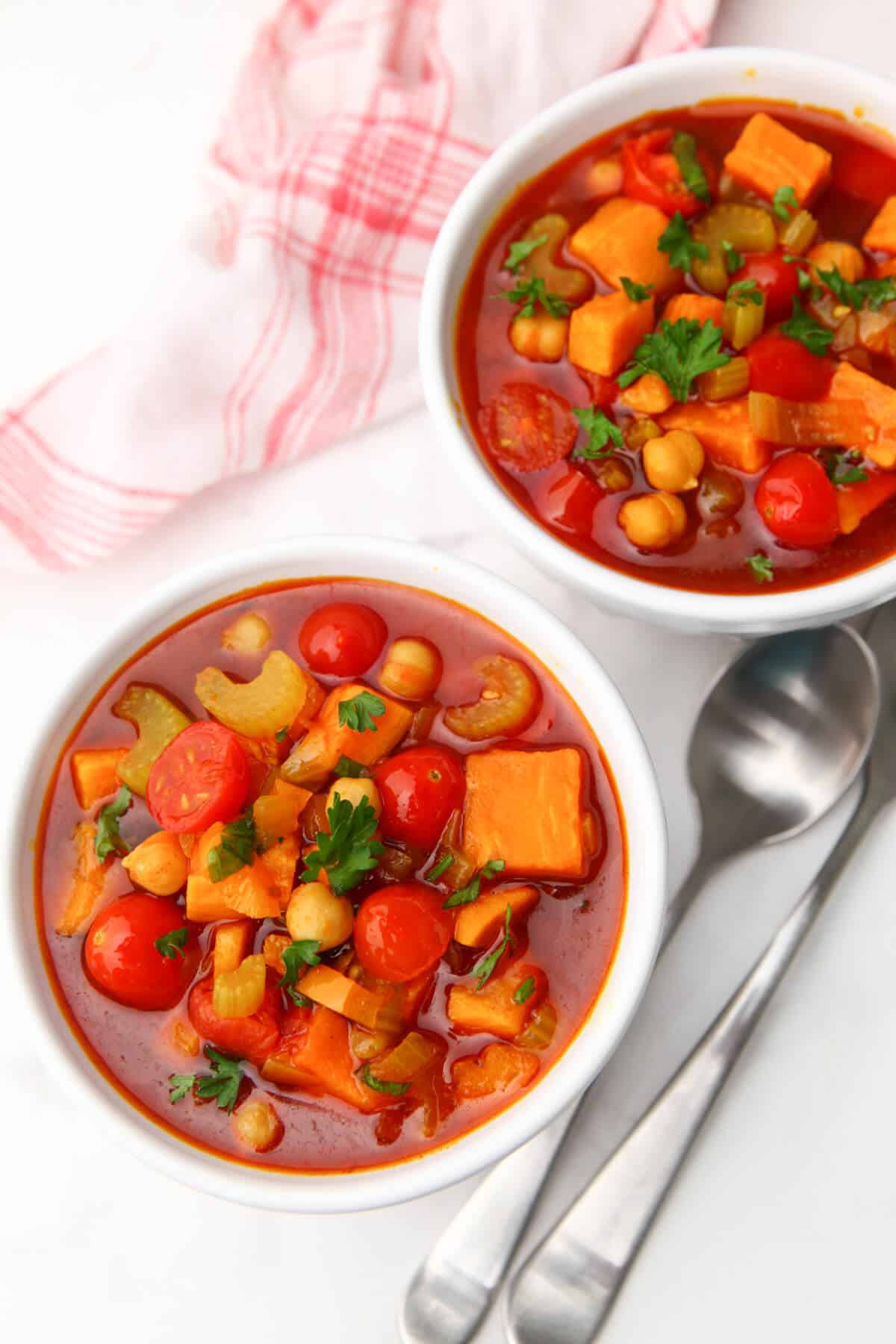 Two bowls of gypsy soup with spoons on the side.