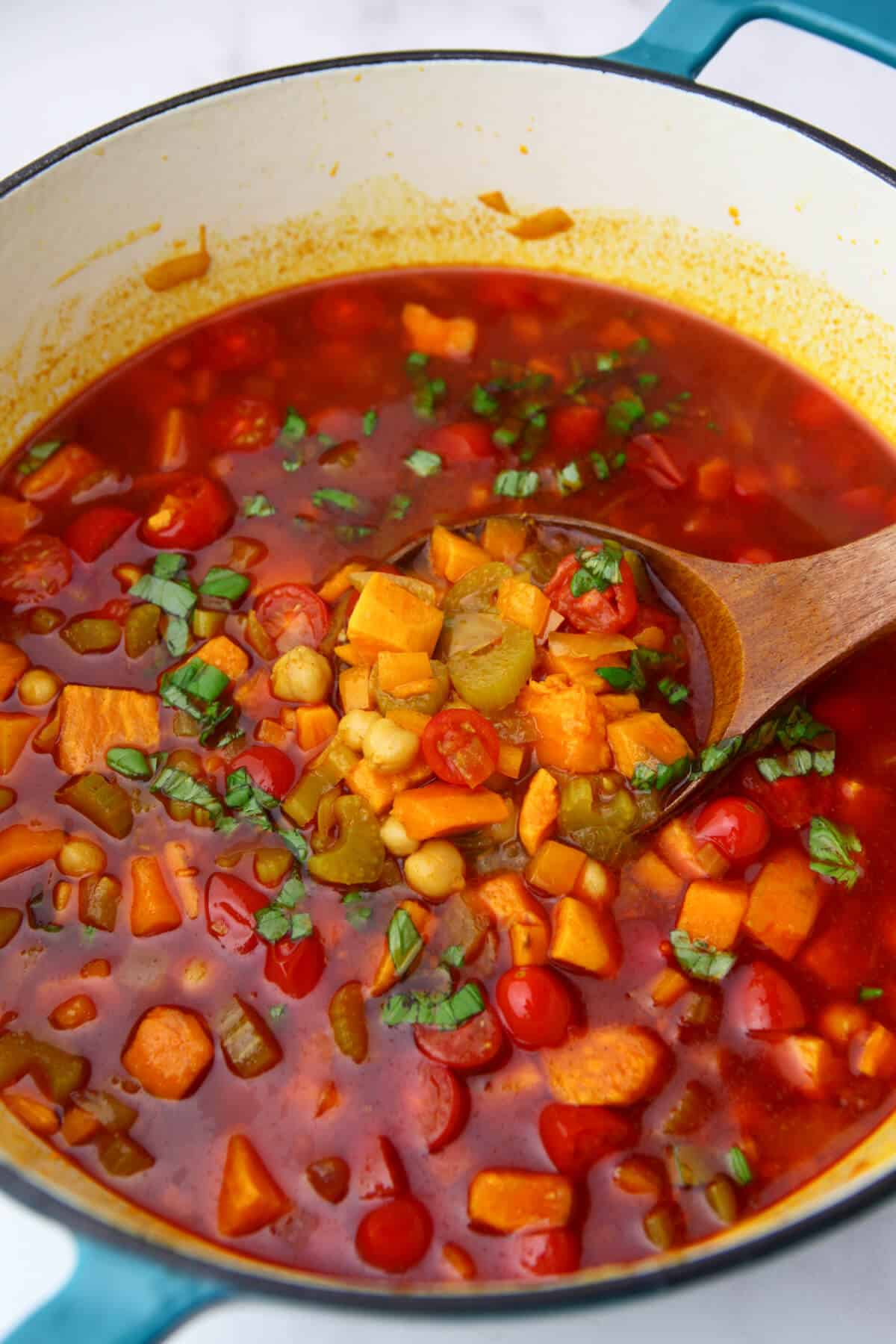 Gypsy soup in a large soup pot being scooped out with a wooden ladel.