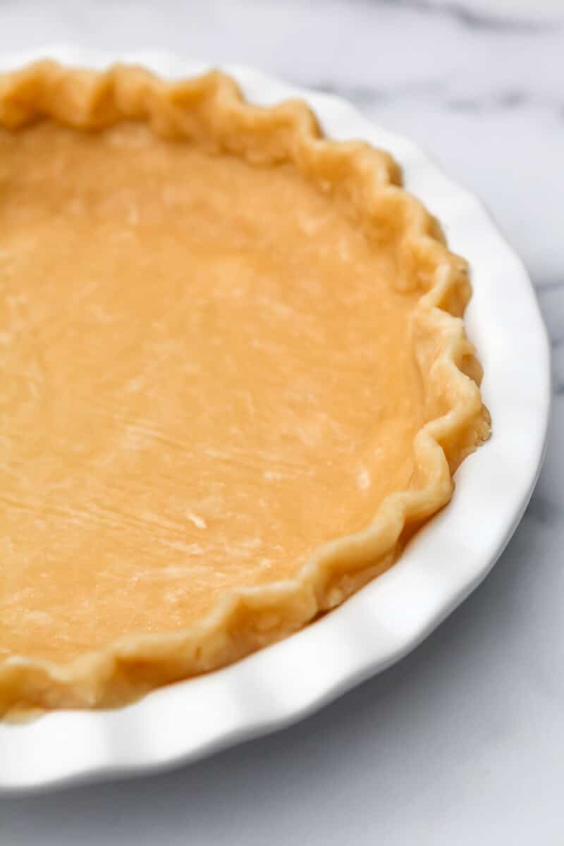 A hot water pie crust formed into a white pie dish.