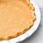 A vegan hot water pie crust in a with pie dish.