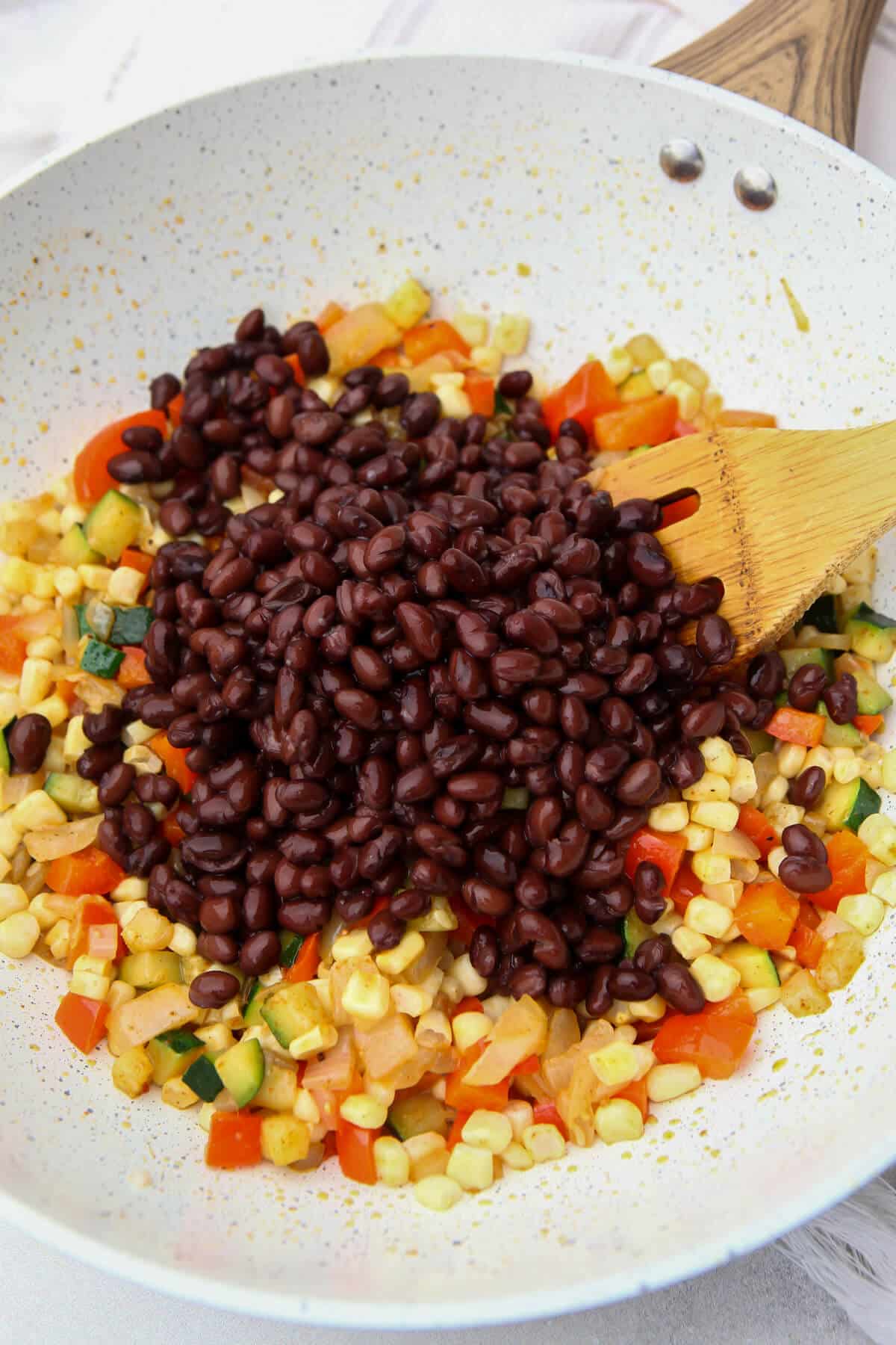 Drained and rinsed black beans added to the sauteed vegetables.