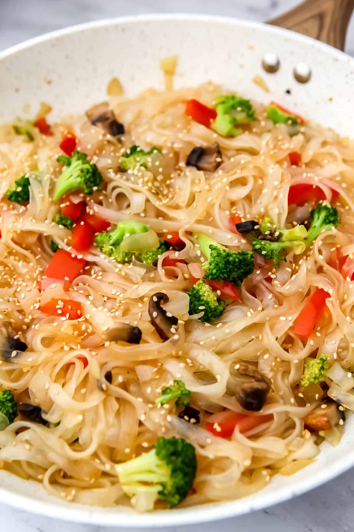 Vegan pad woon sen (stir-fried glass noodles) in a large white wok.