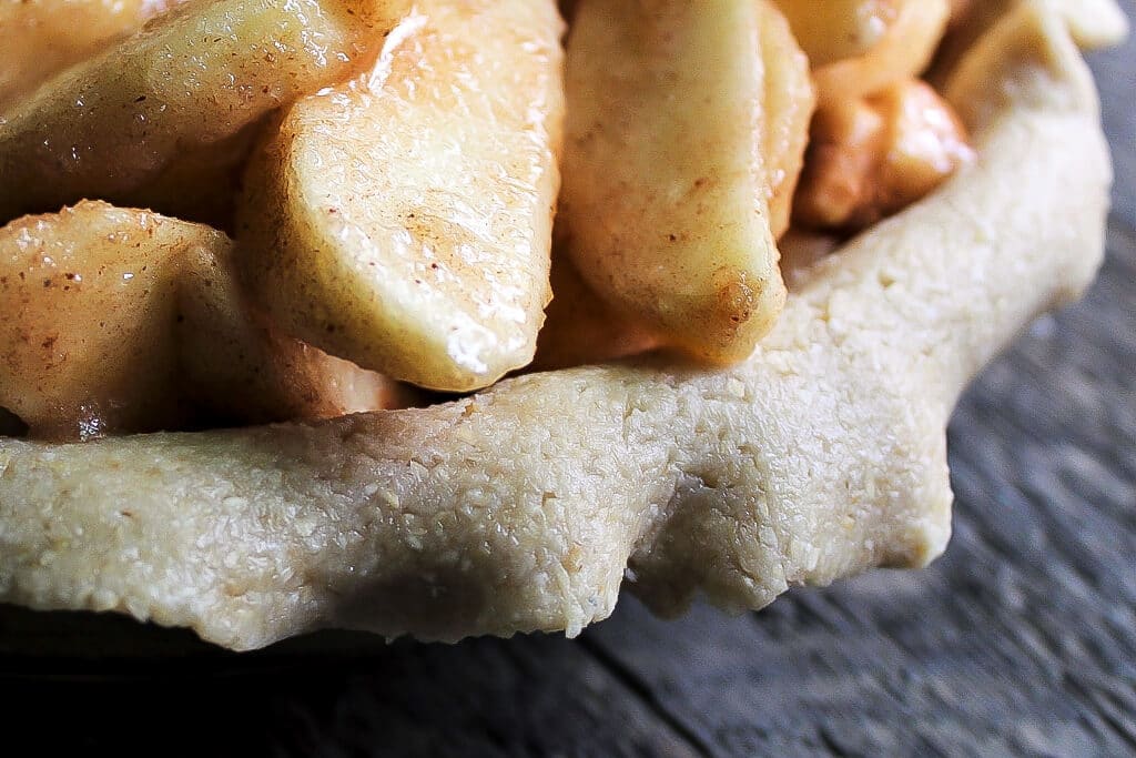 A gluten free vegan pie crust with apples and cinnamon it showing how soft and pliable the crust is.