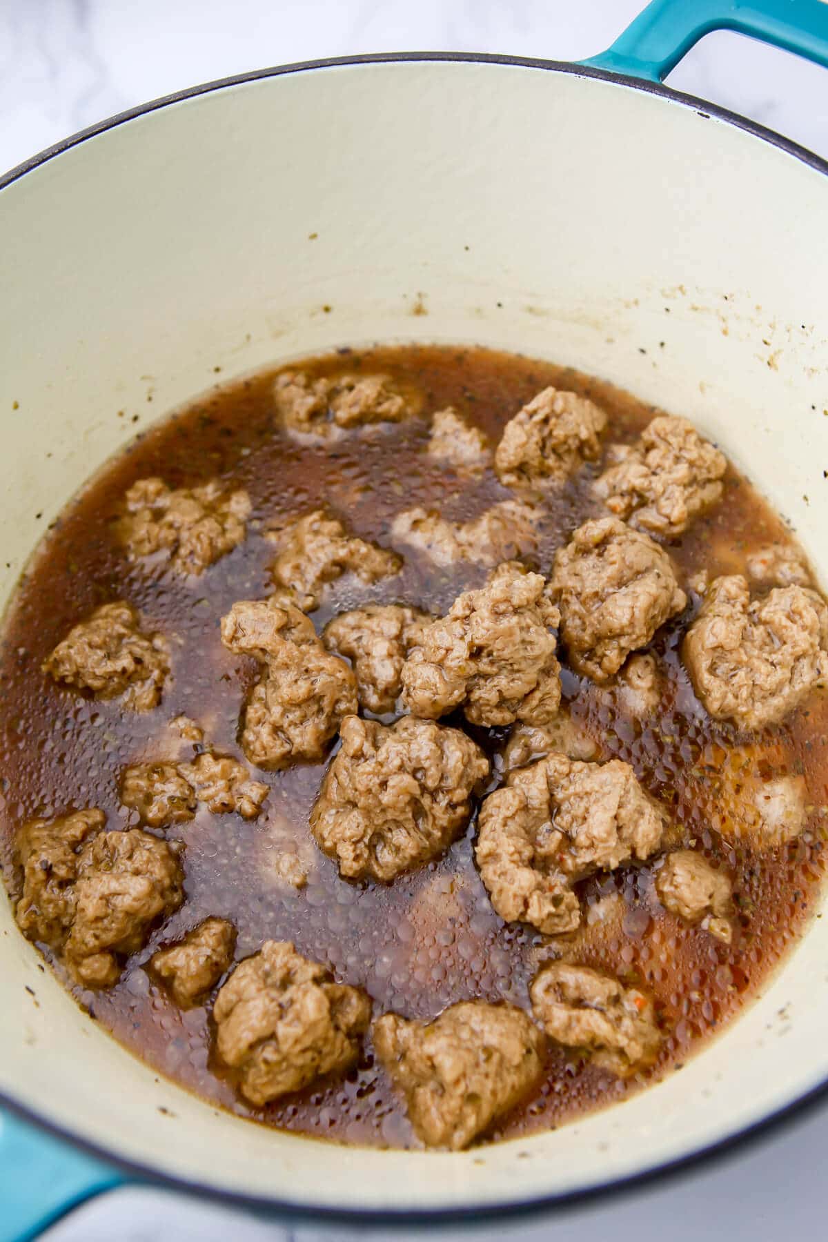 Seitan chunks simmering in a pot.