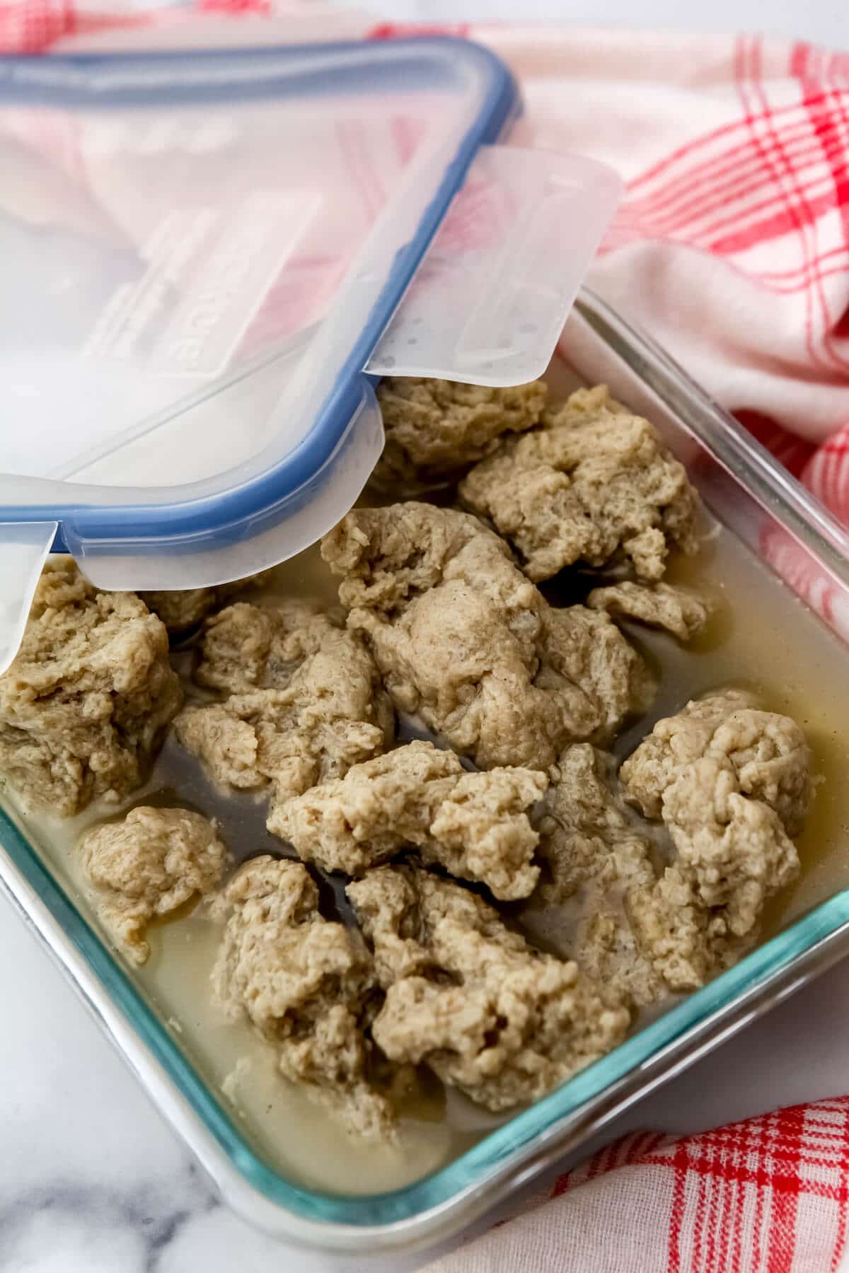 Seitan in broth in a glass container with a lid.