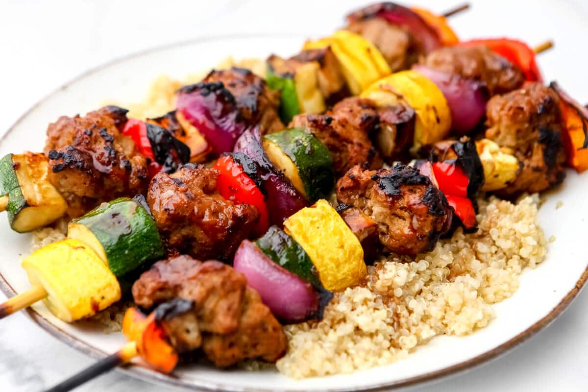 Seitan kebabs with veggies over quinoa with teryiaki sauce over it.