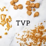 Three different sizes and shapes of TVP on a marble counter top showing chunks, large crumbles, and small crumbles.