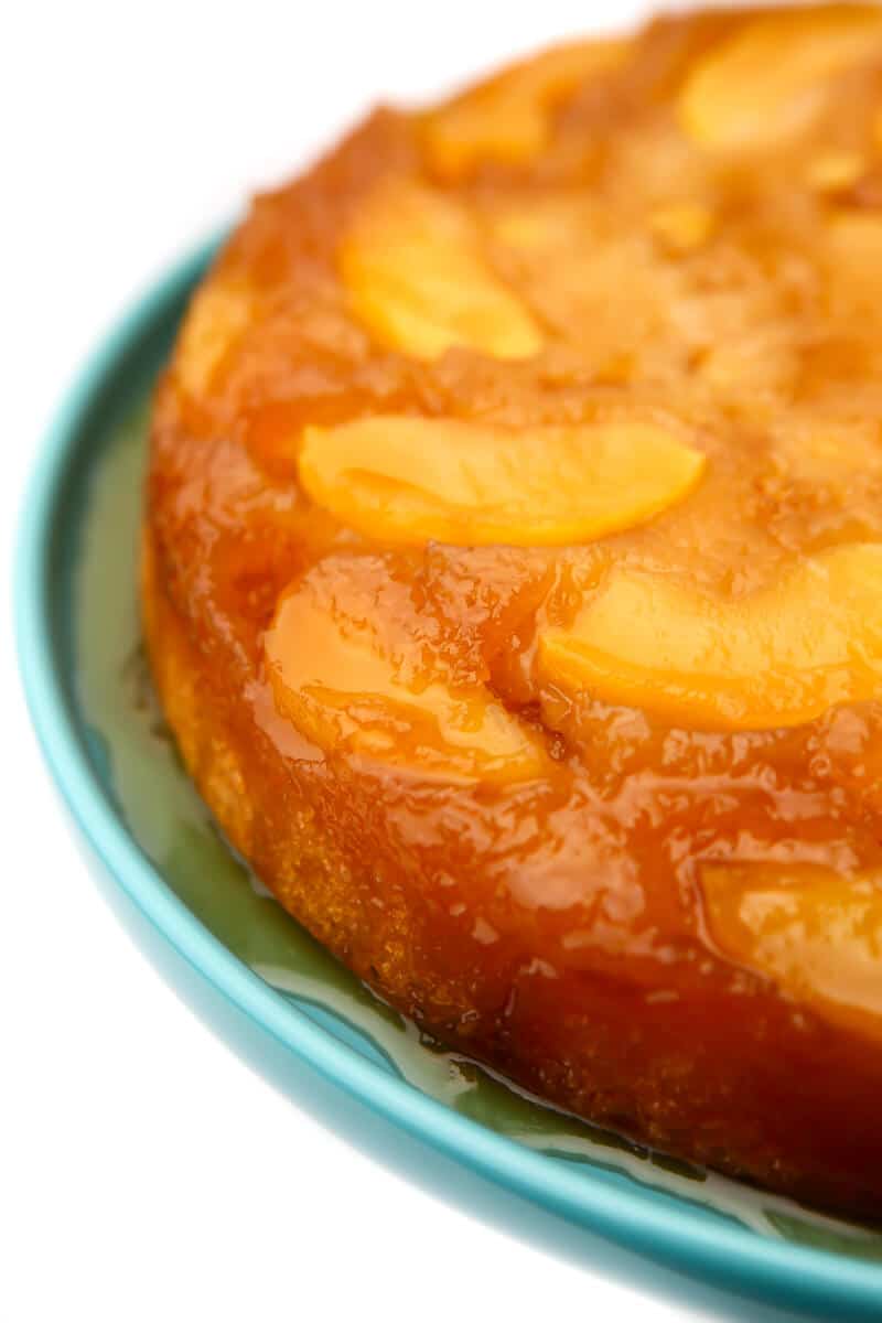 A vegan caramel apple upsidedown cake on a blue cake dish.