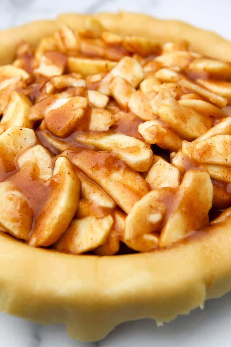 A bottom pie crust filled with apple pie filling.