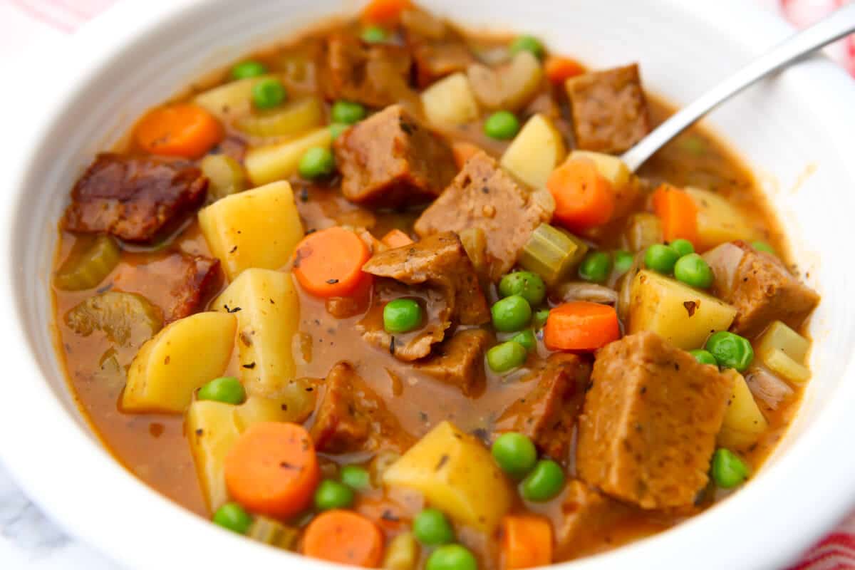 A white bowl filled with hearty vegan beef stew made with seitan.