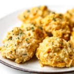 A white plate filled with golden vegan Red Lobster Biscuits.