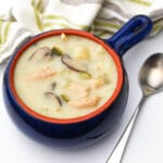 A top view of a bowl of New Mexican style green chile stew made vegan with a spoon beside it.