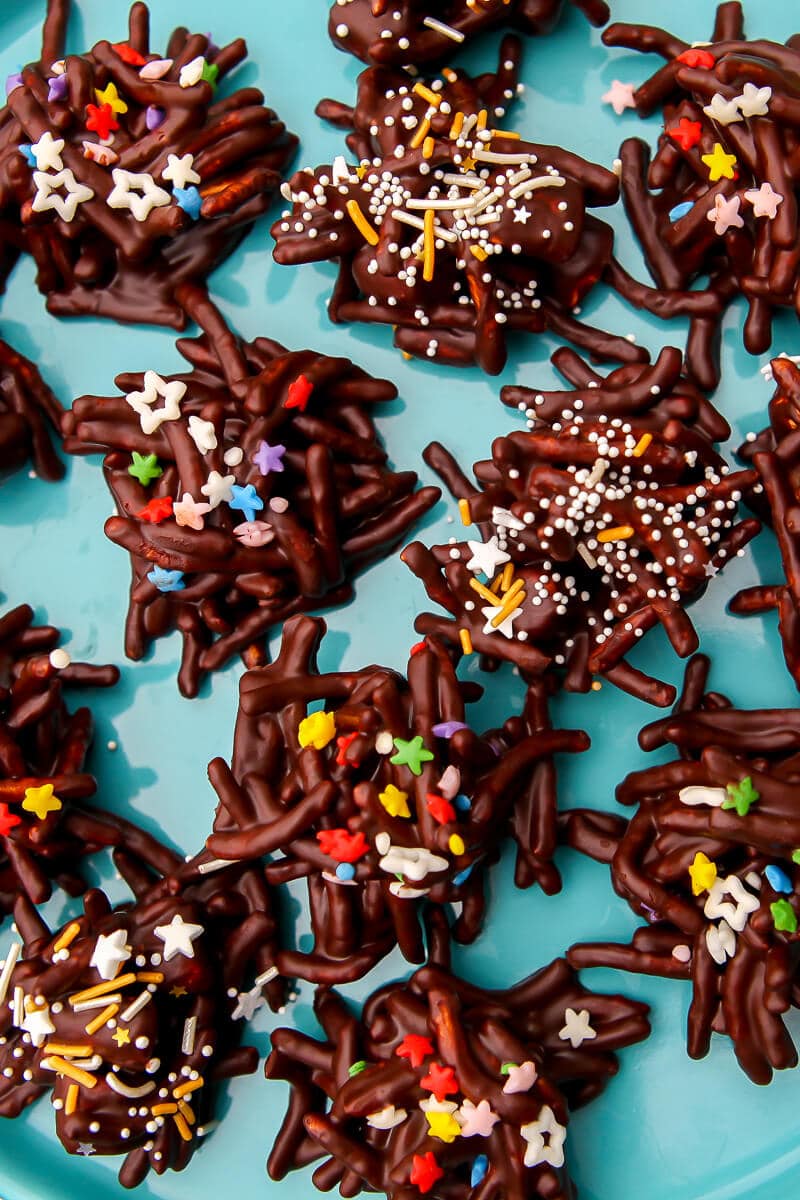 A top view of vegan haystack cookies with sprinkles on a blue plate.