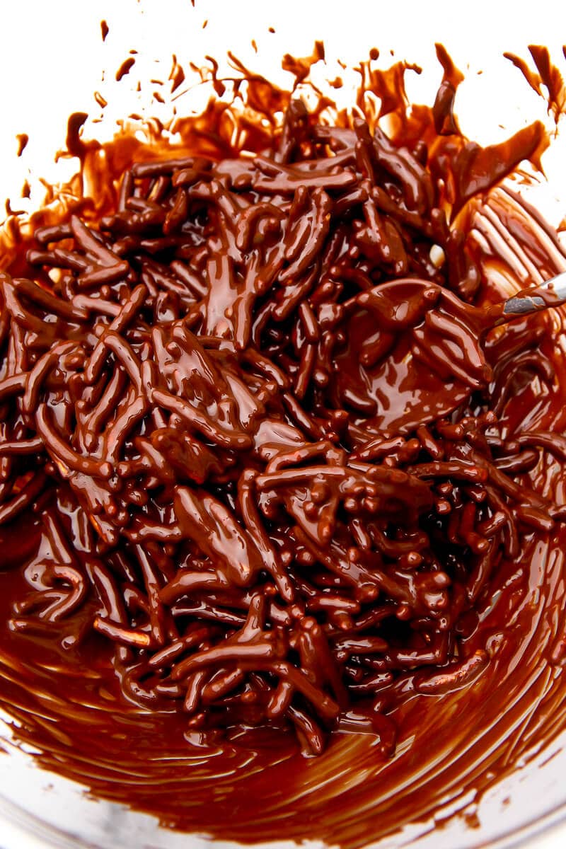 Chow mein noodles being coated in melted chocolate.