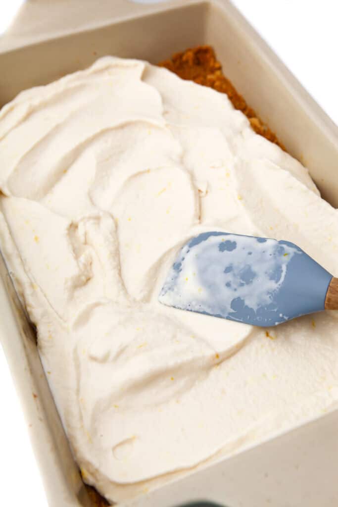 Spreading out the vegan ice cream into a baking dish to make and ice cream cake.