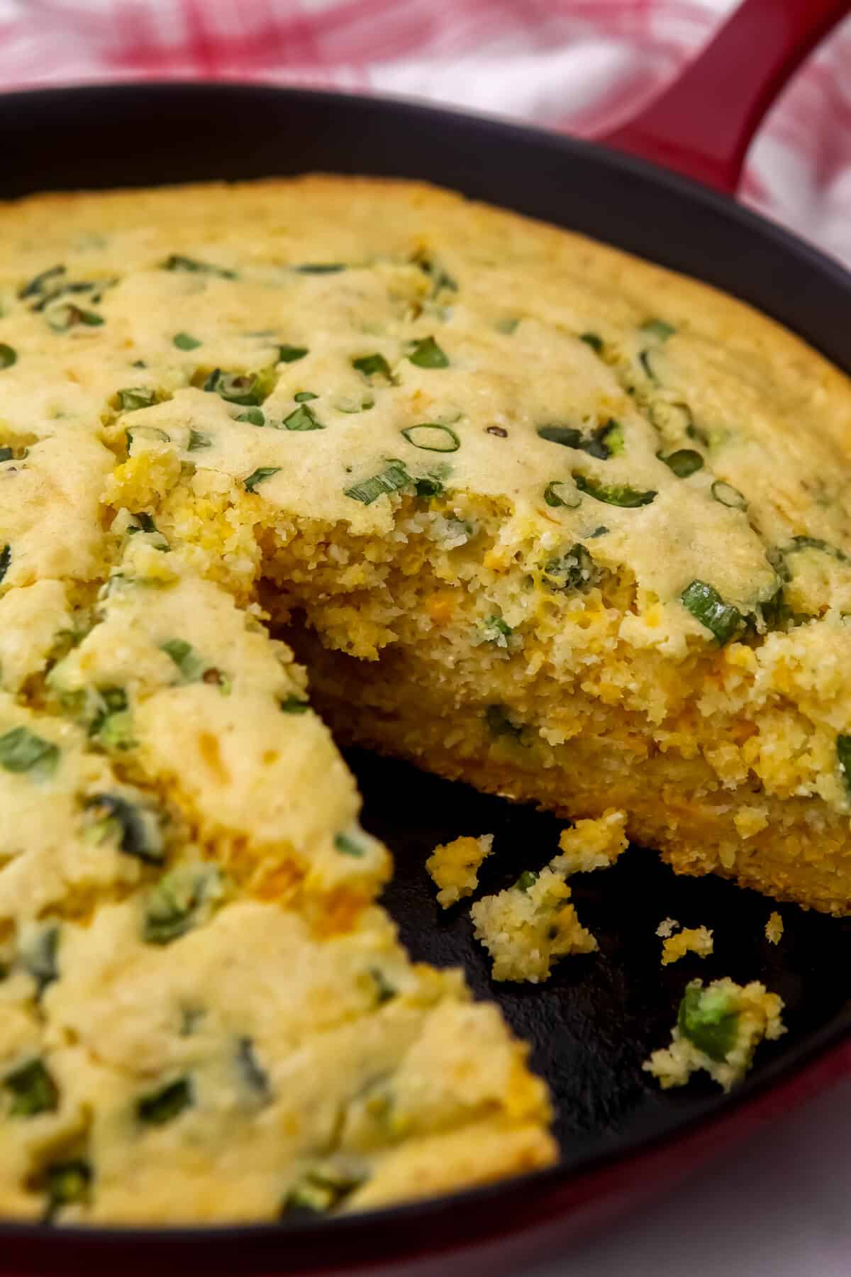 A close up of vegan jalapeno cornbread with a slice taken out of it.