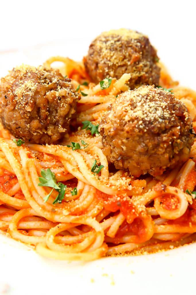 Vegan spaghetti and meatballs on a white plate.