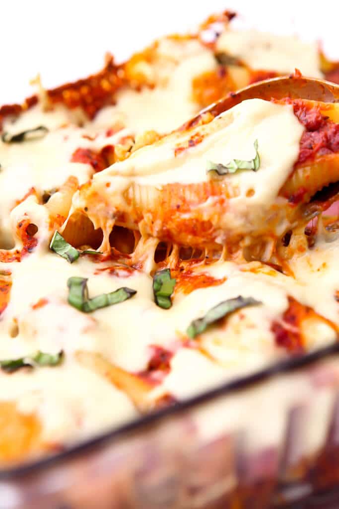 Stuffed shells topped with vegan cheese that is melted and stretchy on top.