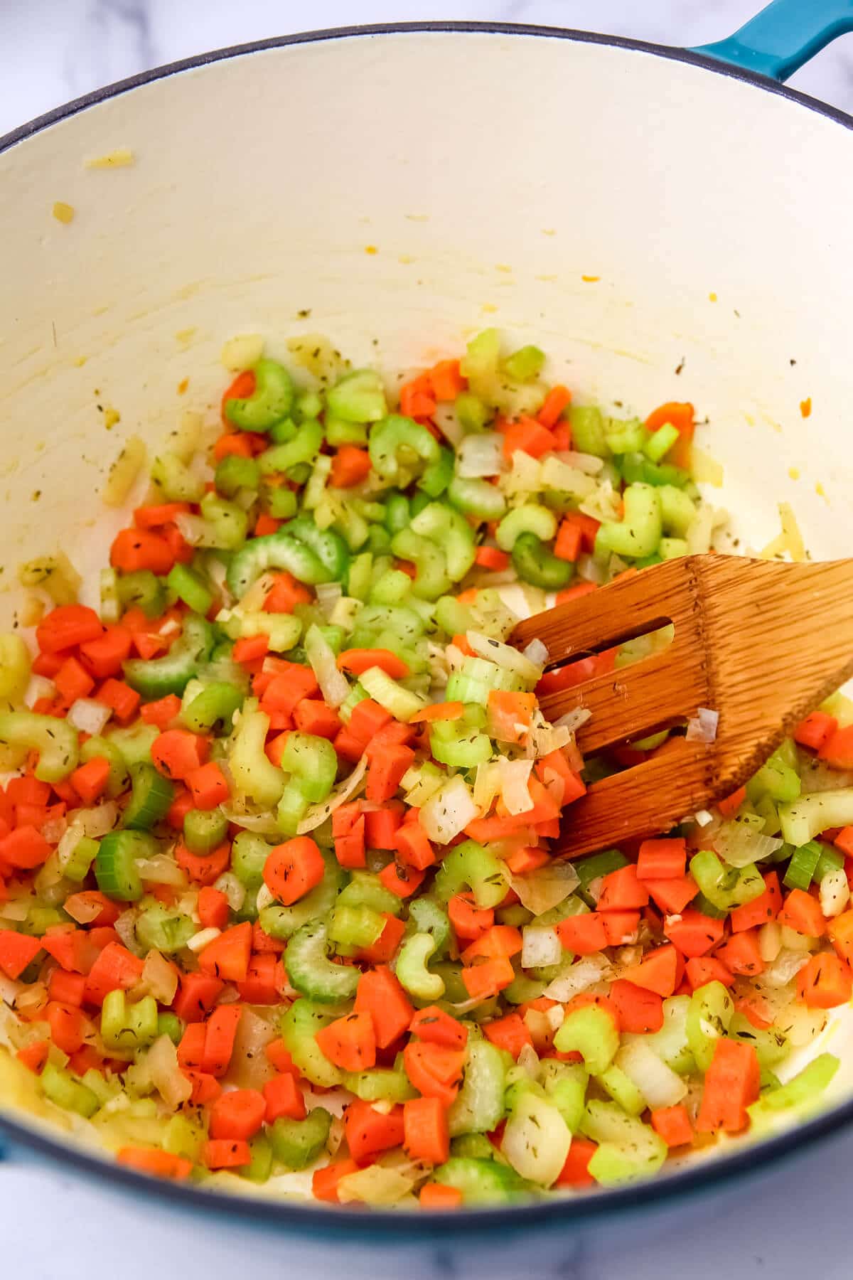 Onions, carrots, celery, and garlic sauteing in a soup pot.