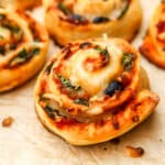 Vegan pizza rolls on a piece of brown parchment paper.