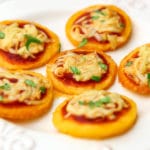 Vegan polenta pizza bites on a white plate.