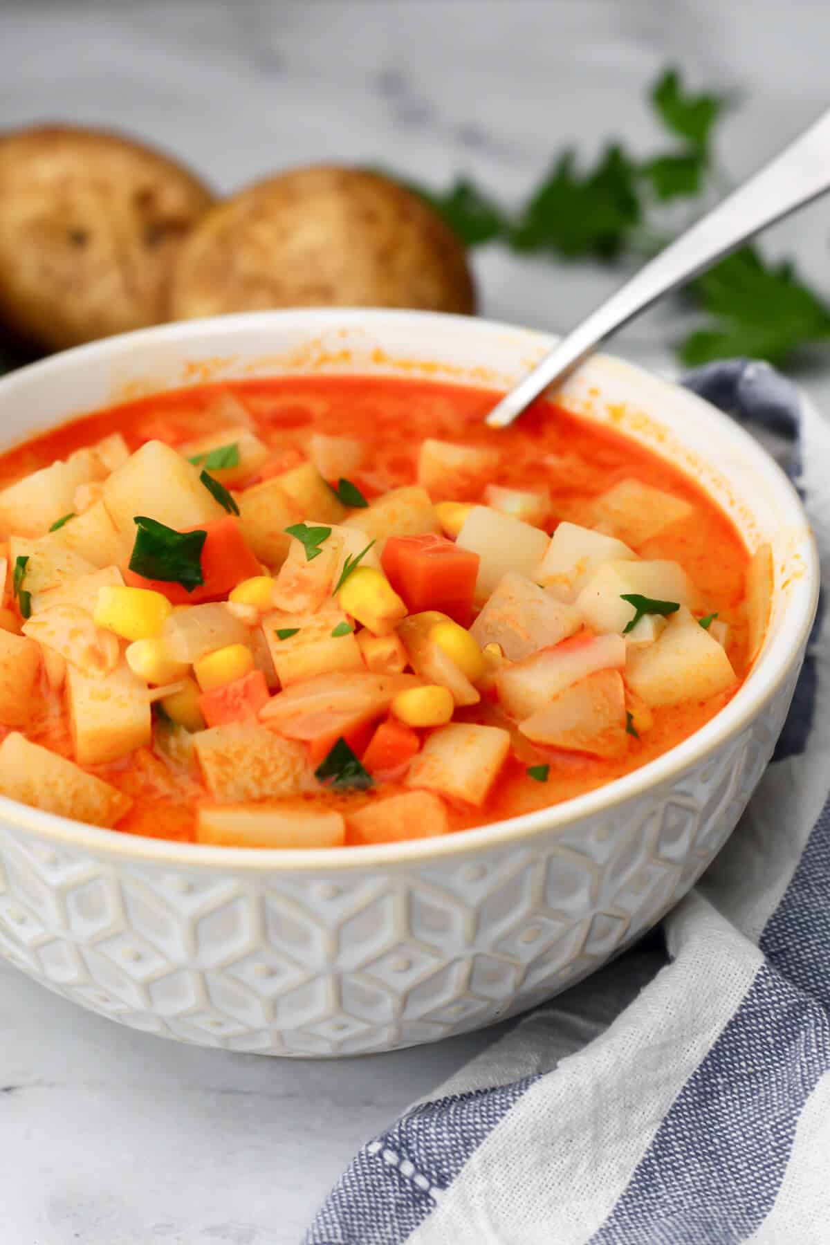 A white bowl filled with smokey vegan potato corn chowder.