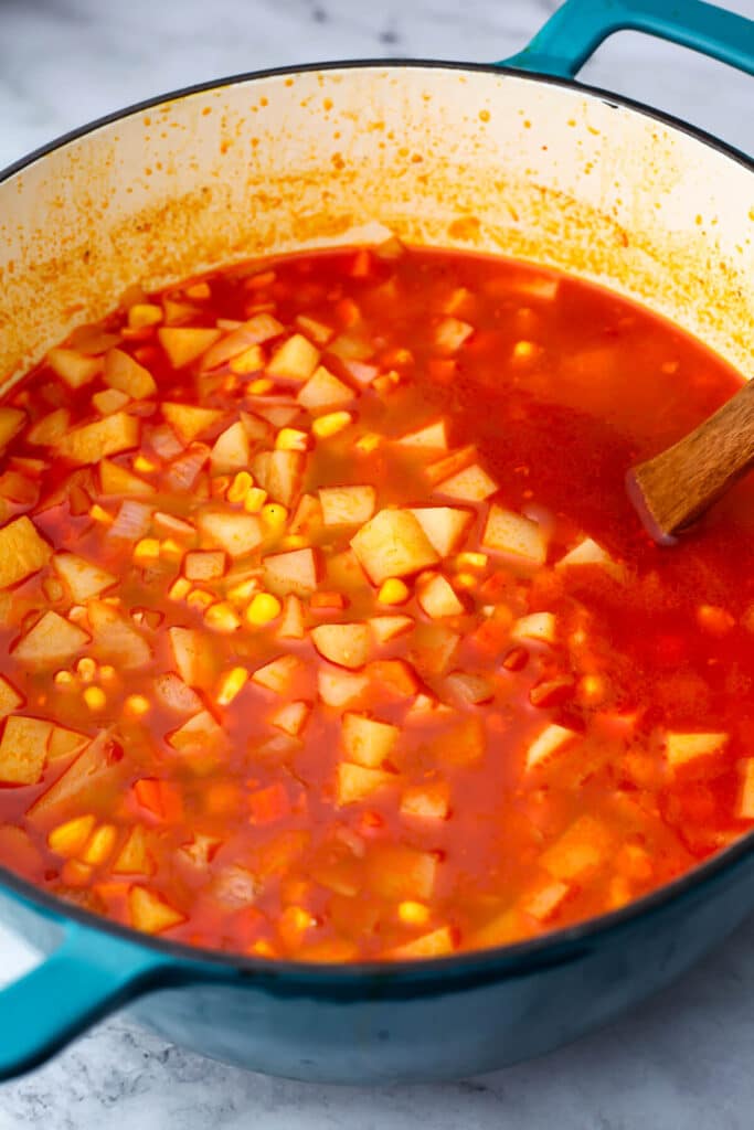 Broth, corn, and potatoes added to the vegan chowder.