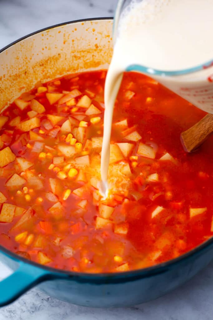 Soy milk being added to the vegan potato corn chowder to make it creamy.