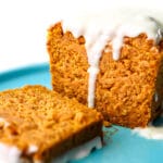 A loaf of vegan pumpkin bread with a slice cut off of it.