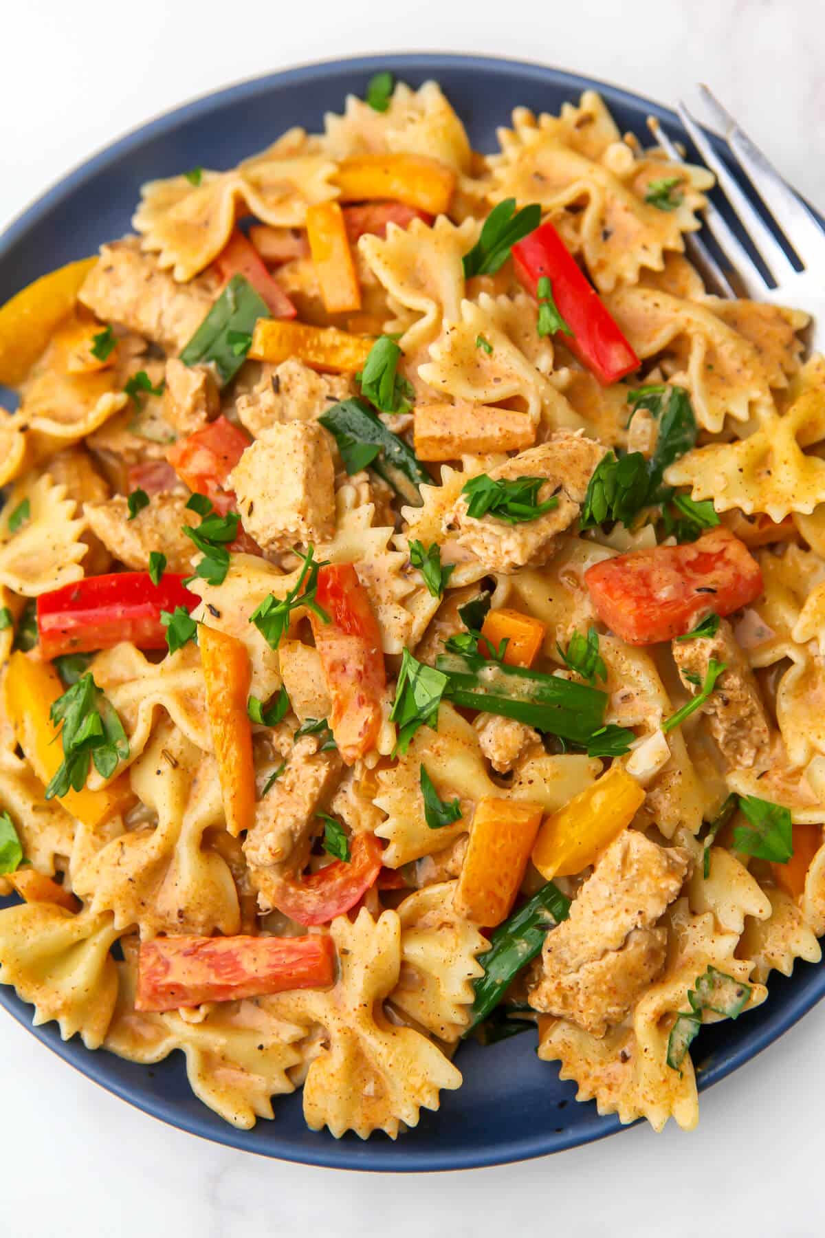 A top view of a vegan Jamaican Jerk pasta served on a blue plate.