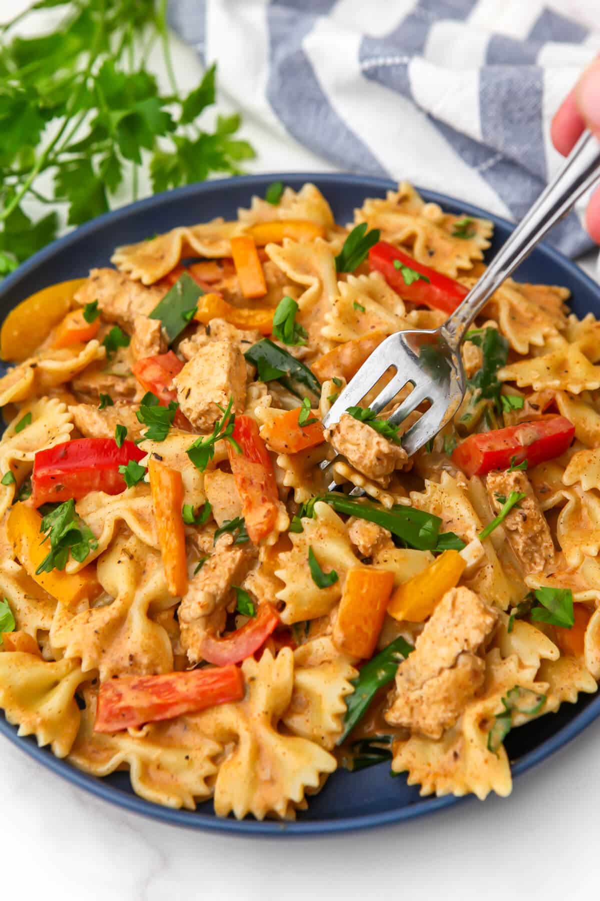 A plate full of creamy vegan Rasta pasta made with bell peppers, and coconut milk with Jamaican Jerk seasoning.