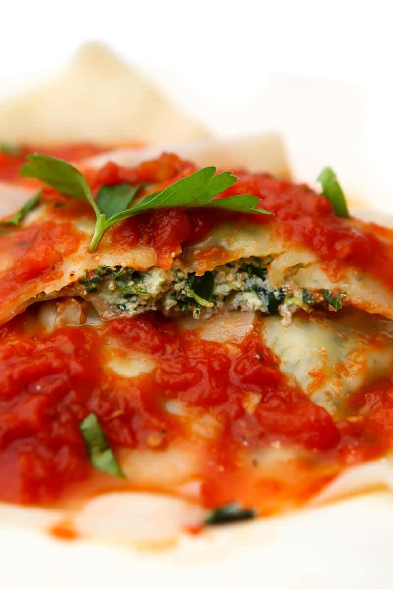 A close up of a spinach ravioli showing the inside of it.