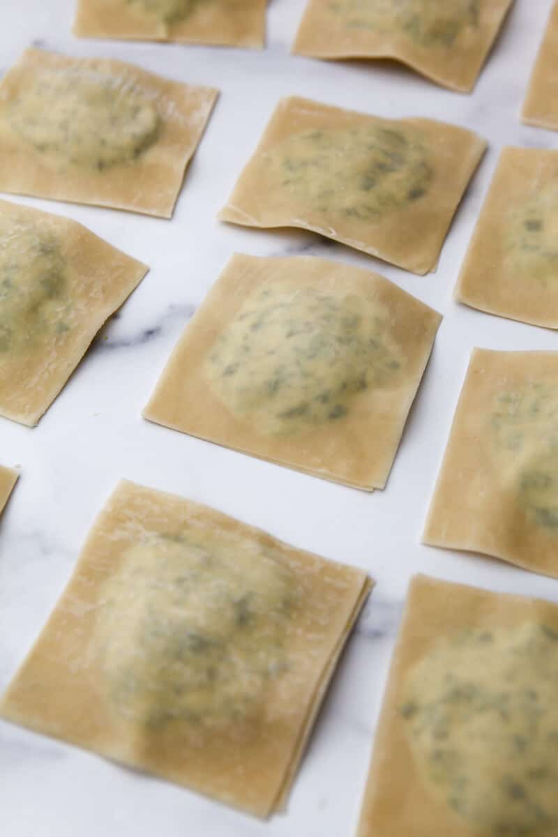 Assembled tofu ravioli on a marble countertop. 