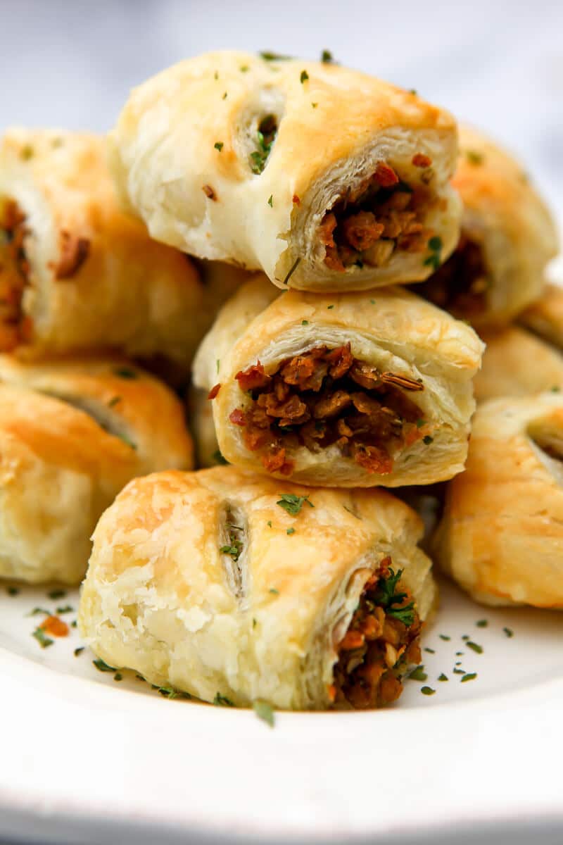 A stack of vegan sausage rolls made with puff pastry stacked on top of each other. 