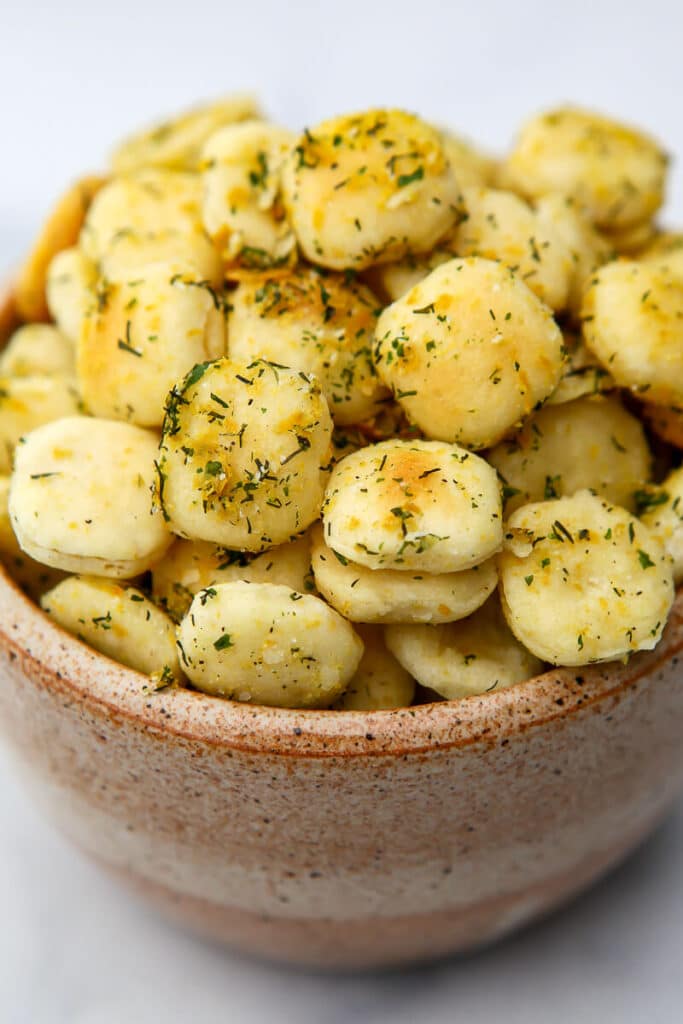 A bowl of vegan seasoned oyster crackers with ranch style seasoning.