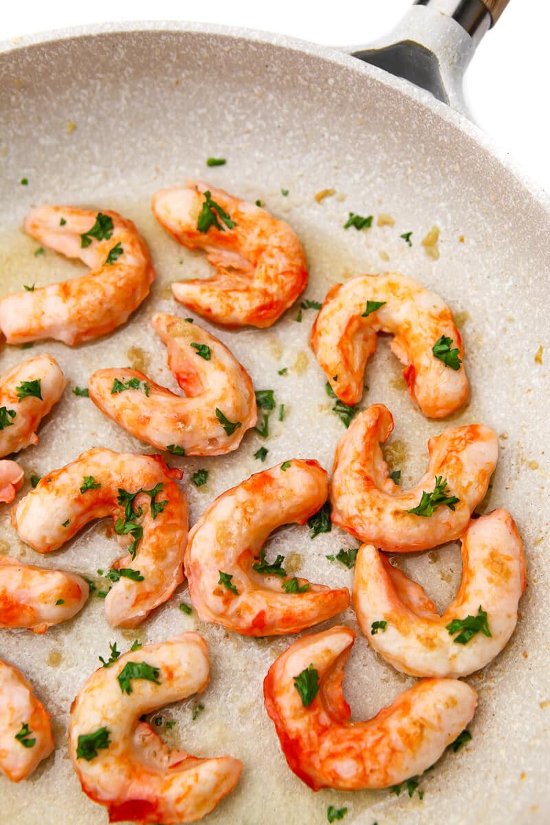 Frozen store-bought vegan shrimp being sauted in a skillet.