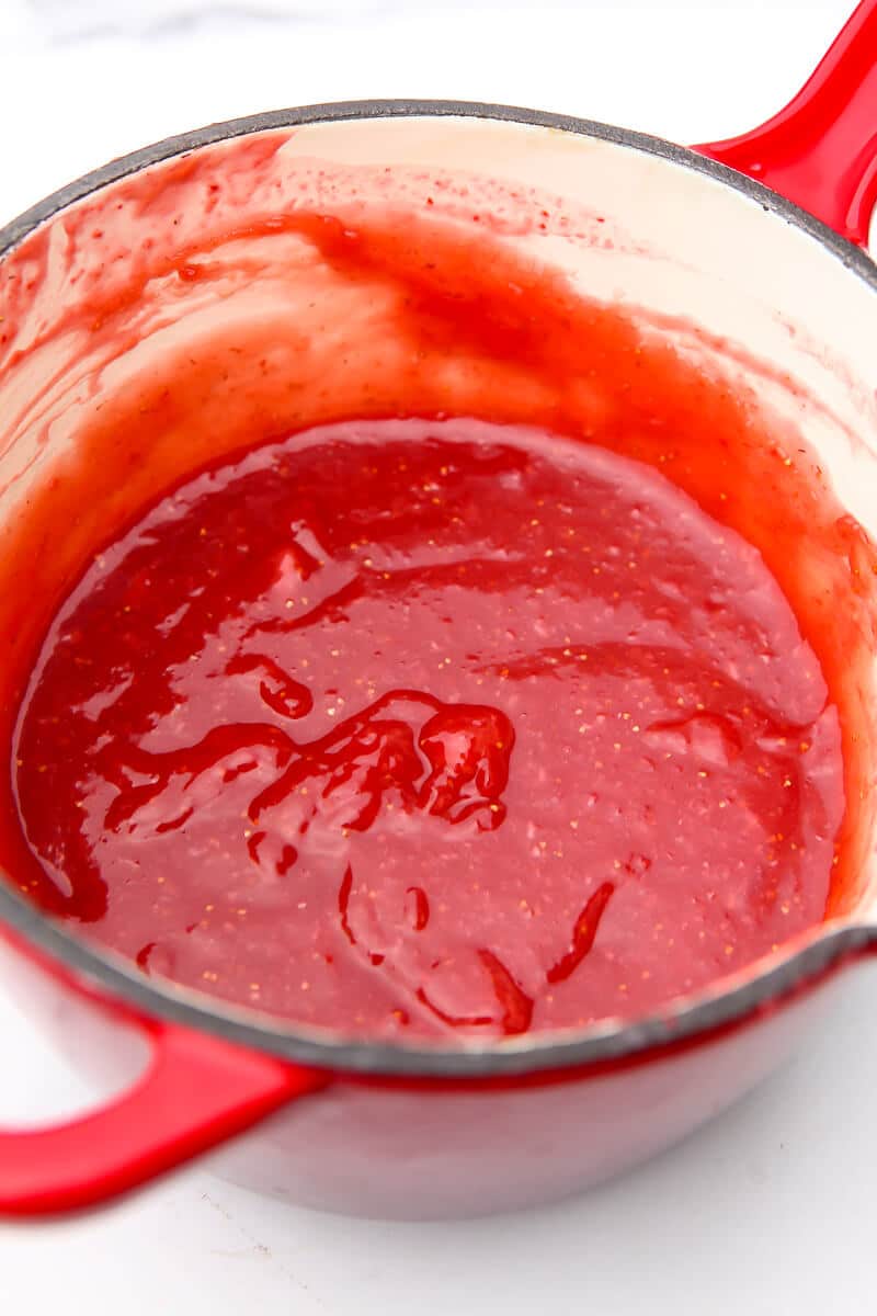 A saucepan of strawberry sauce before pouring over strawberry pie.