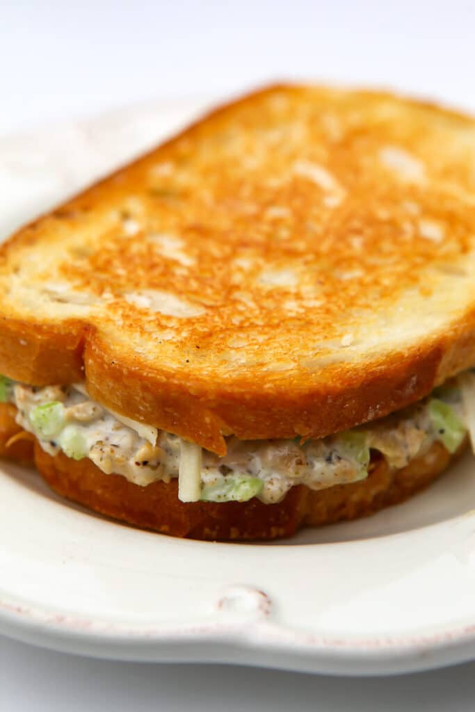 A grilled vegan tuna melt on a white plate.